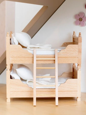Dollhouse miniature light wood twin bunk beds with ladder and white bedding.