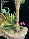 Closeup of 1:12 miniature scale tropial garden in raised stone bed