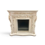 An ornate miniature cream-colored fireplace mantel with intricately carved gold painted details.